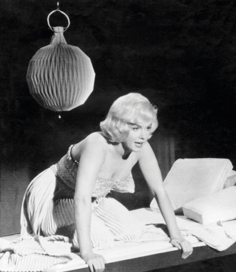 Marilyn Monroe fra en filmoptagelse i sort/hvid med lampen Frugtlygten hængende i baggrunden
